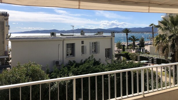 Varanda com vista para a costa, incluindo edifícios e um corpo de água.