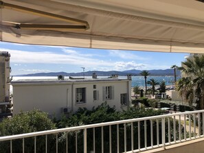 En balkon med udsigt over et kystlandskab, inklusive bygninger og et vandareal.