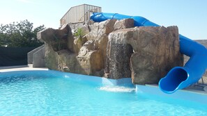 Una piscina con uno scivolo acquatico blu.