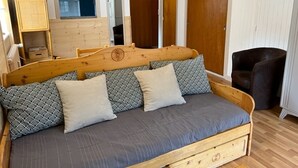 A wooden bed with a headboard, grey bedding, and two pillows. - Bright 2-Room with Balcony and WIFI - Village Center (Brides-les-Bains)