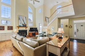 A spacious living room with a fireplace, a large sofa, a coffee table, and a television. - About 400ft to Ships Watch Beach Access - Walk to Duck (Duck)