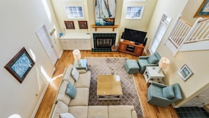 A spacious living room with a large sofa, a coffee table, and a fireplace.
