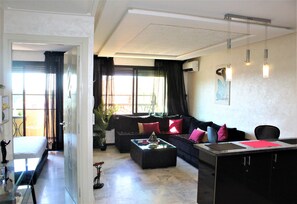 A modern living room with a sofa, coffee table, and a dining area with a table and chairs.