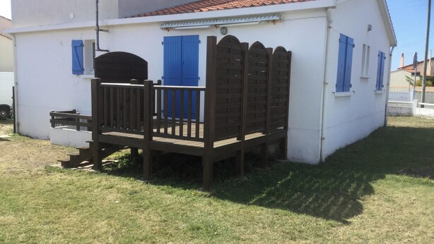 A small white building with blue shutters, a wooden deck, and a single door. - Homerez - House/Garden, Saint-Hilaire-de-Riez (Saint-Hilaire-de-Riez)