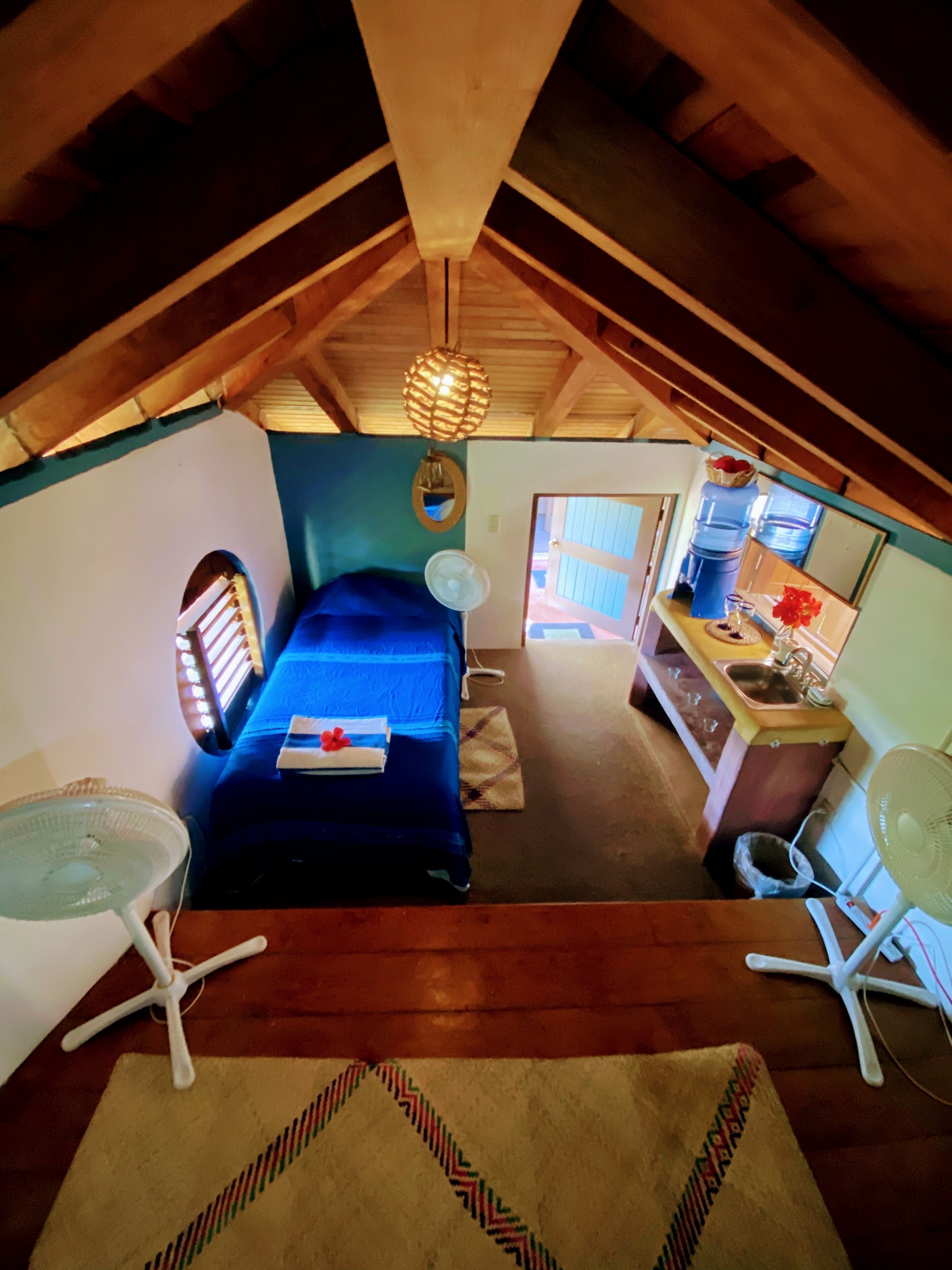 Acogedor dormitorio en el ático con cama, escritorio y kitchenette.