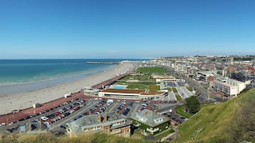 Eine Küstenstadt mit Strand, Burg und Parkplatz.