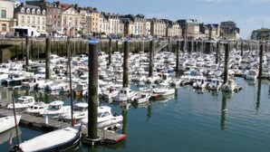 A marina filled with numerous boats docked at wooden piers, surrounded by historic buildings. - Le Verdier (Dieppe)