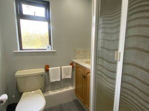 A bathroom with a toilet, a sink, and a shower.