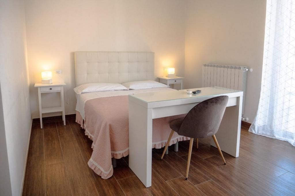 Una camera da letto con un letto, comodini, una scrivania e una sedia.