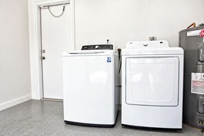 A laundry room with two front-loading washing machines and a dryer. - Centrally located 3Br2Ba Pool Home available for LONGER STAYS, Monthly Discounts (Port St. Lucie)