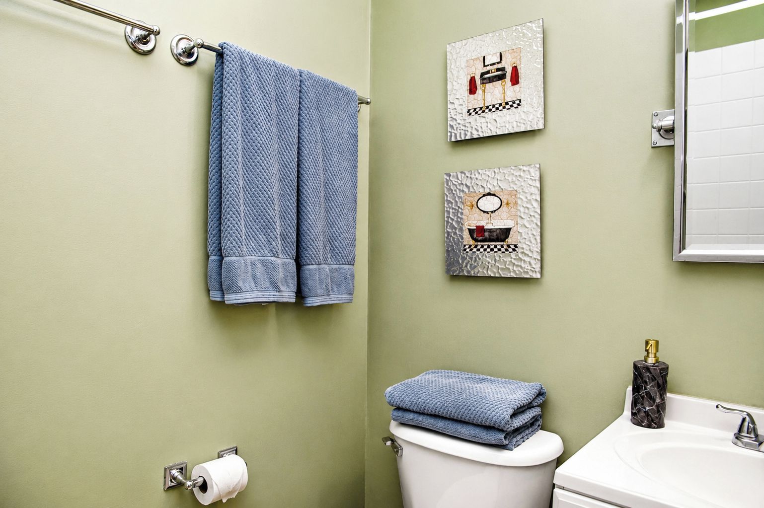 A bathroom with a toilet, sink, and towel rack.
