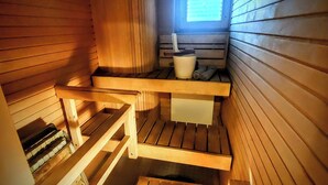 A sauna with wooden benches, a window, and a bucket. - Superb sijainti + hiljaisuus + sauna (Helsinki)