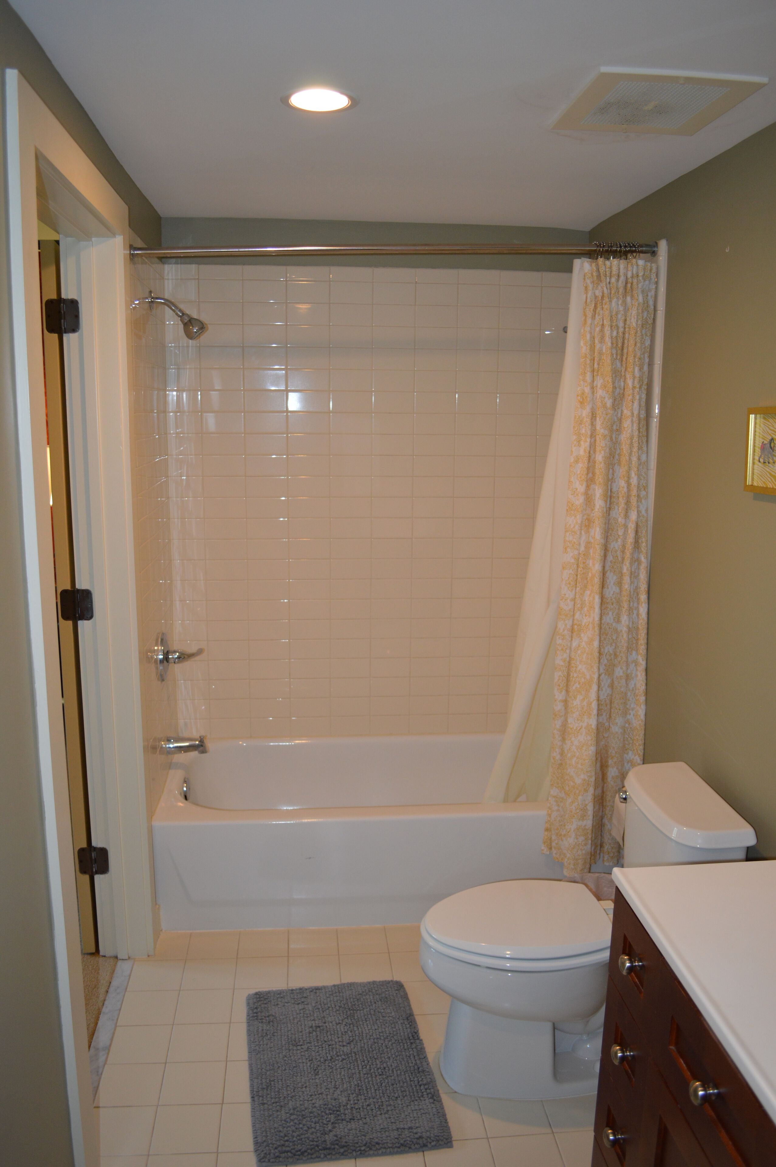 A bathroom with a bathtub, toilet, and a shower curtain.