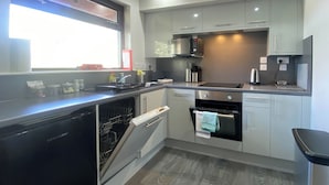 A modern kitchen with a dishwasher, oven, microwave, and a coffee maker. - 3 bedroom accommodation in Oban (Oban)