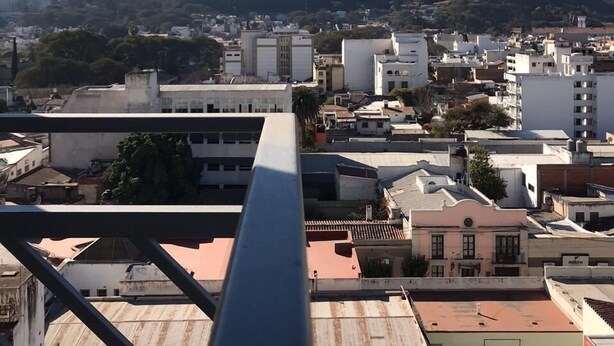 A cityscape with buildings and a mountain in the background. - Departamento Belgrano 6 (Salta)