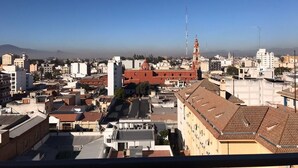 A cityscape with a prominent red-roofed building and a tall tower in the distance. - Departamento Belgrano 6 (Salta)