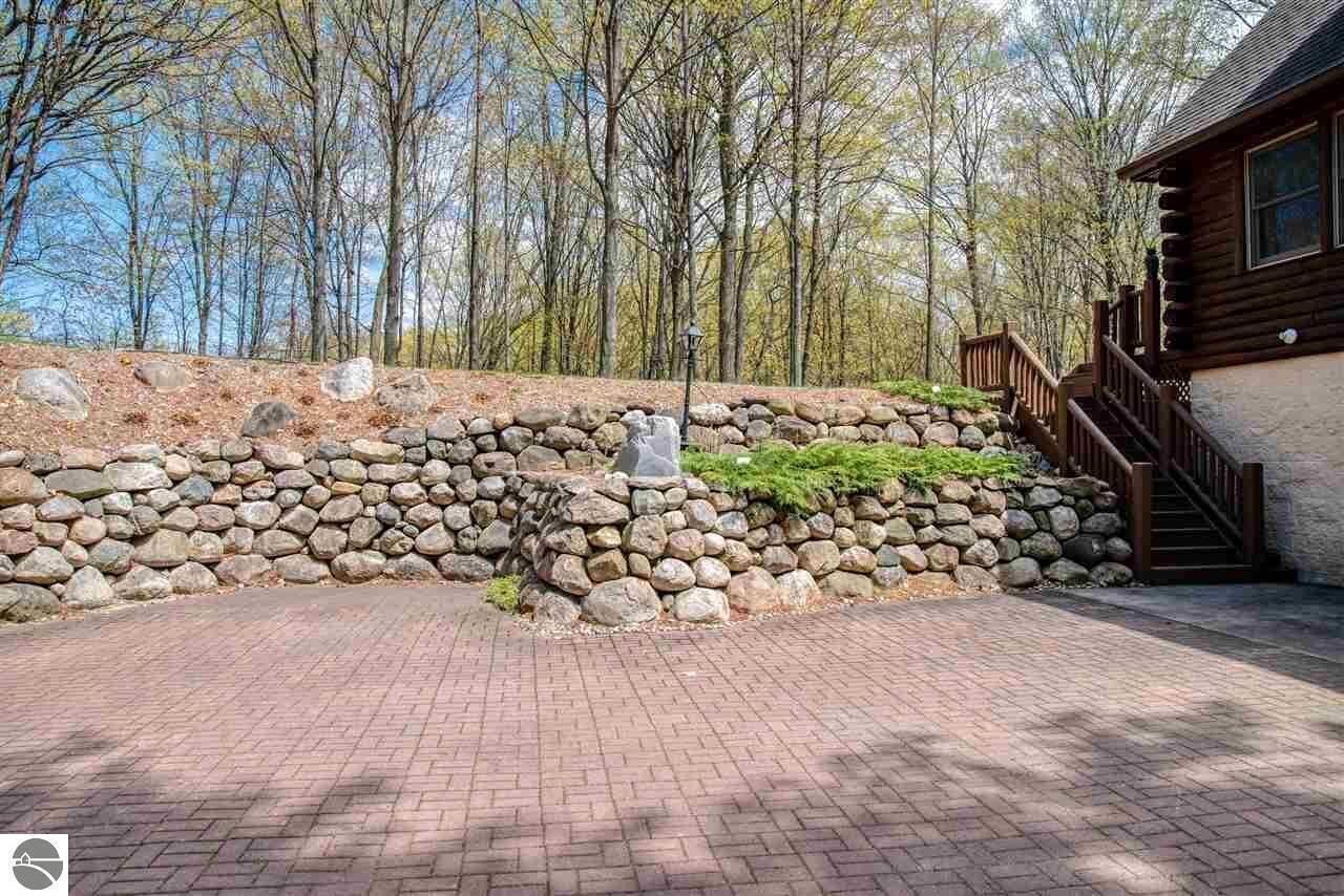 A stone retaining wall with a wooden staircase leading to a cabin.