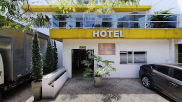 Un hotel con fachada amarilla, un letrero que dice "HOTEL" y un cartel que indica "La Sultana".