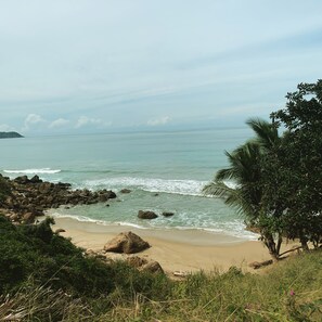 Una playa cerca, arena blanca, sombrillas, toallas de playa