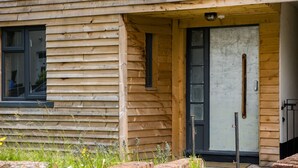 Eine Holzhütte mit Haustür, Fenster und einer kleinen Veranda.