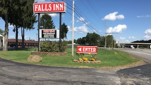 A sign for Falls Inn with amenities like free Wi-Fi, breakfast, and micro-fridge. - Falls Inn (Newton Falls)