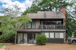 A two-story house with a balcony, a covered patio, and a garage.