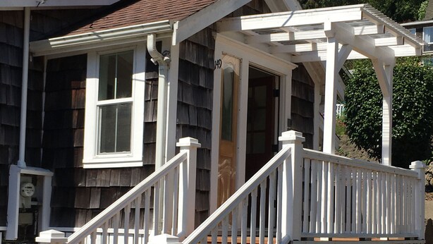 A house with a porch, a staircase, and a number '49' sign.
