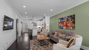 Un salon moderne avec un canapé, une table basse et un téléviseur fixé au mur.