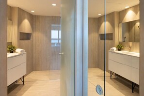A modern bathroom with two sinks, mirrored cabinets, and a glass partition. - Luxurious Apt W Panoramic Sea View - 75m (Tel Aviv)