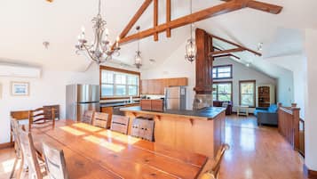 Una cocina amplia con vigas de madera, una isla grande y electrodomésticos modernos.