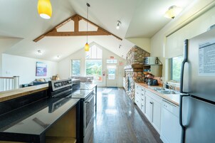 A modern kitchen with a central island, built-in appliances, and a stone accent wall.
