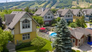A residential area with houses, a swimming pool, and a view of green hills. - Blue View Chalets (The Blue Mountains)