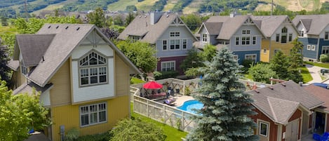 Zona residencial con casas, una piscina y vistas a colinas verdes.