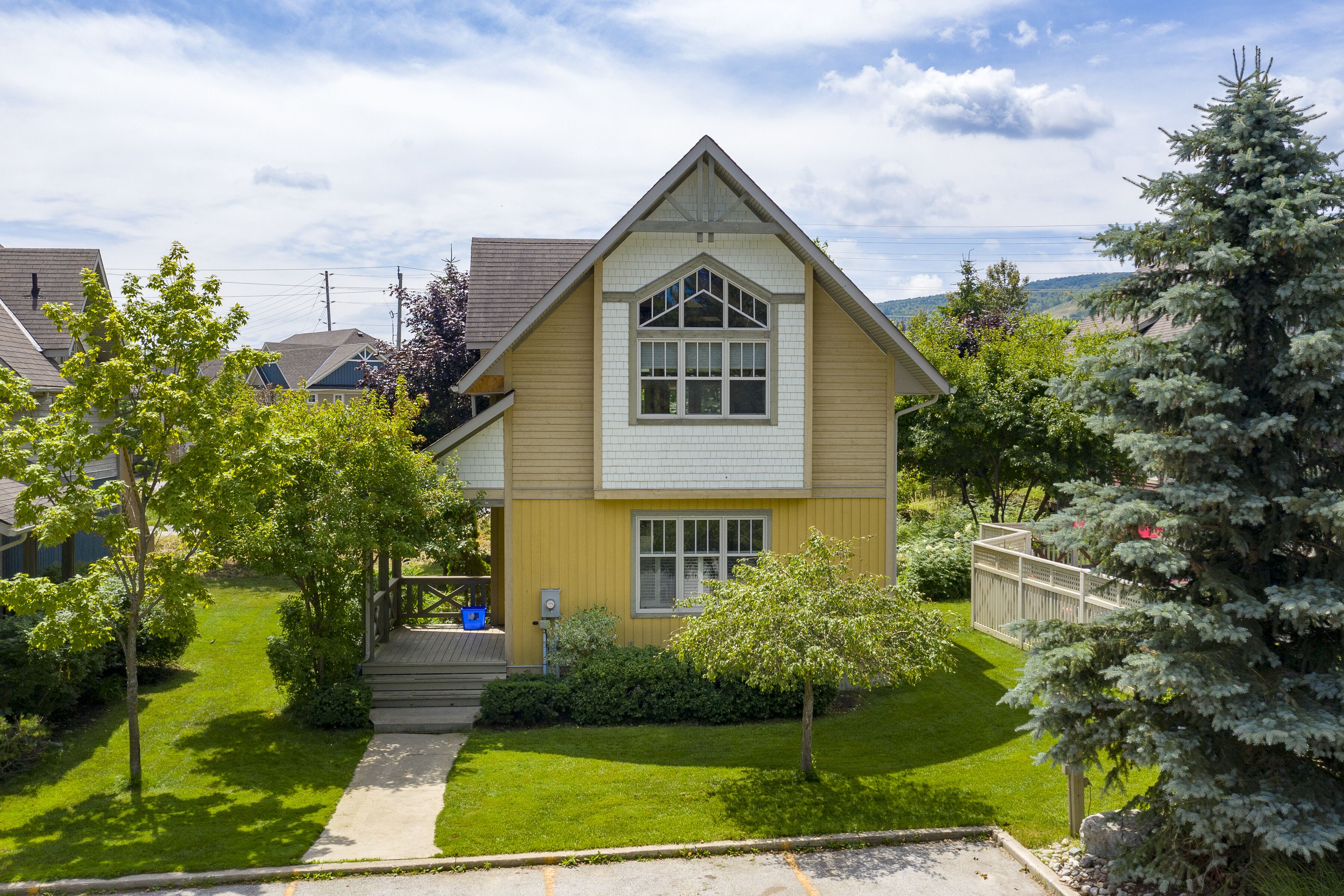 A two-story house with a gabled roof, a front porch, and a well-maintained lawn.