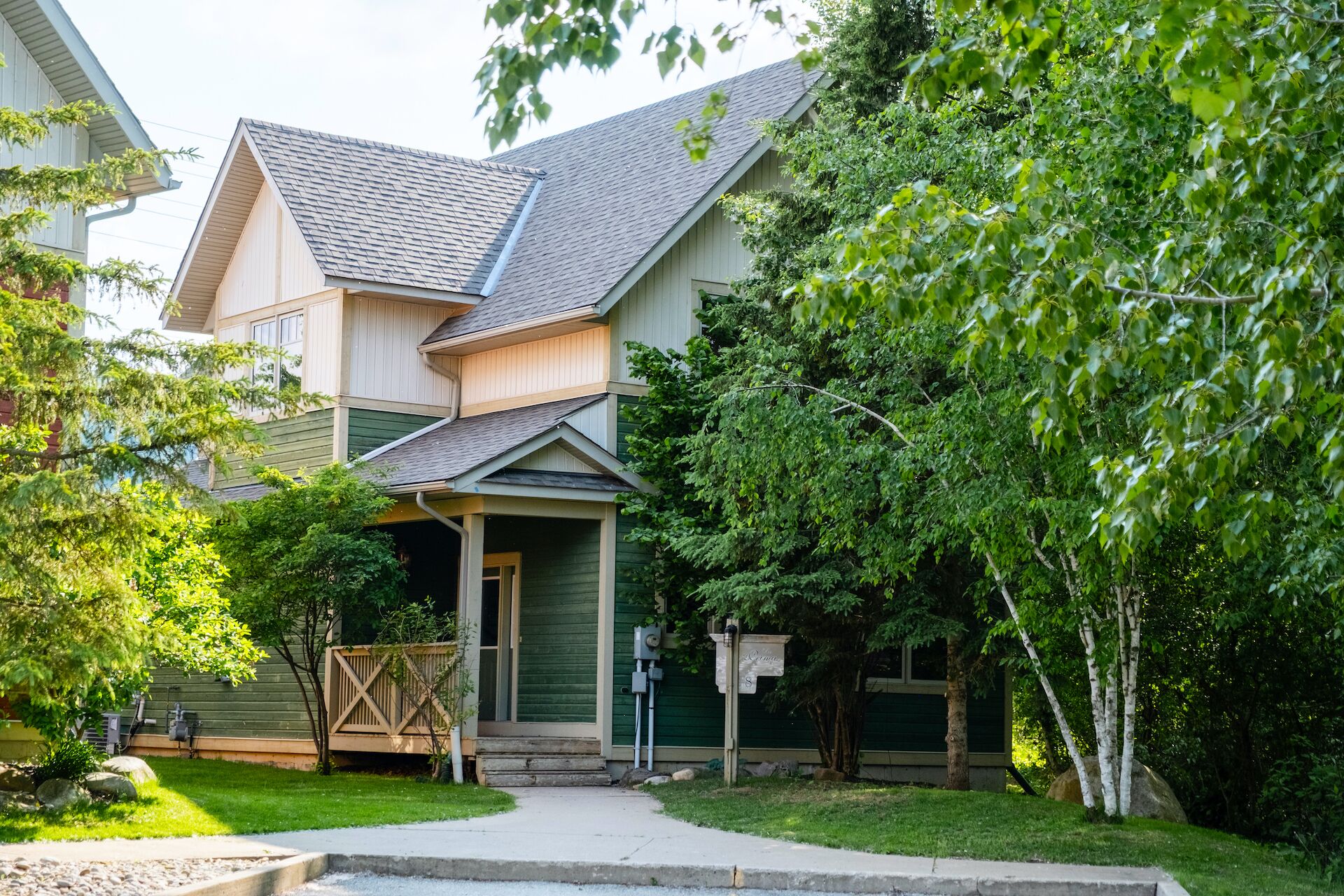 A two-story house with a front porch, a garage, and a well-maintained lawn.