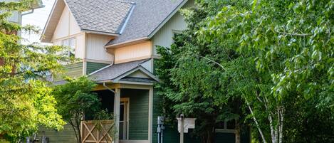 A two-story house with a front porch, a garage, and a well-maintained lawn.