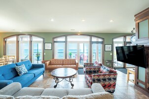 A spacious living room with a blue sofa, a brown leather couch, and patterned armchairs.