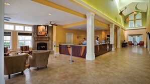 A spacious lobby with a fireplace, seating area, and a reception desk.