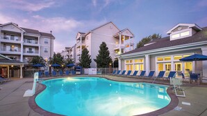 A swimming pool surrounded by lounge chairs and umbrellas, with a building in the background. - Country Music's finest Modern Resort by Grand Ole Opry & Convention Center (Nashville)