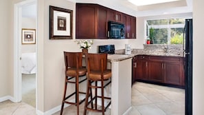 Enjoy meals in this well-equipped kitchen with a granite countertop, bar stools, and a microwave.
