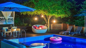 An outdoor pool area with lounge chairs, a wicker sofa, and umbrellas. - Greenhill Pension (Pyeongchang)