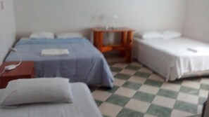 A room with two beds, a small table, and a checkered floor. - Yucatan Vista Inn (Mérida)