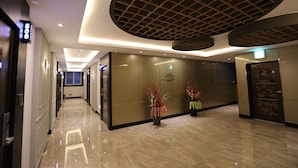 A modern hotel lobby with a long corridor, a reception desk, and a large decorative ceiling. - Pohang Jukdosijang Idea Hotel (Pohang)