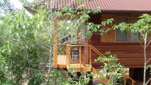 A wooden cabin with a wooden deck and a small staircase leading to a door. - Eskapo Verde Lodge Moalboal (Badian)