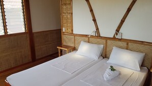 A double bed with white linens, a small wooden nightstand, and a woven headboard. - Eskapo Verde Lodge Moalboal (Badian)