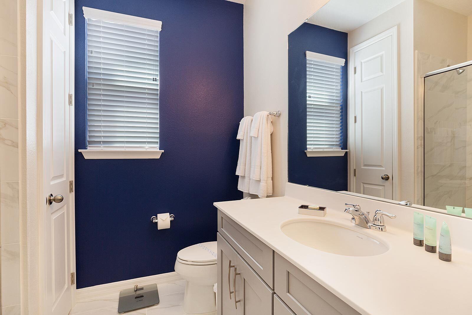 A bathroom with a white sink, a mirror, and a toilet.