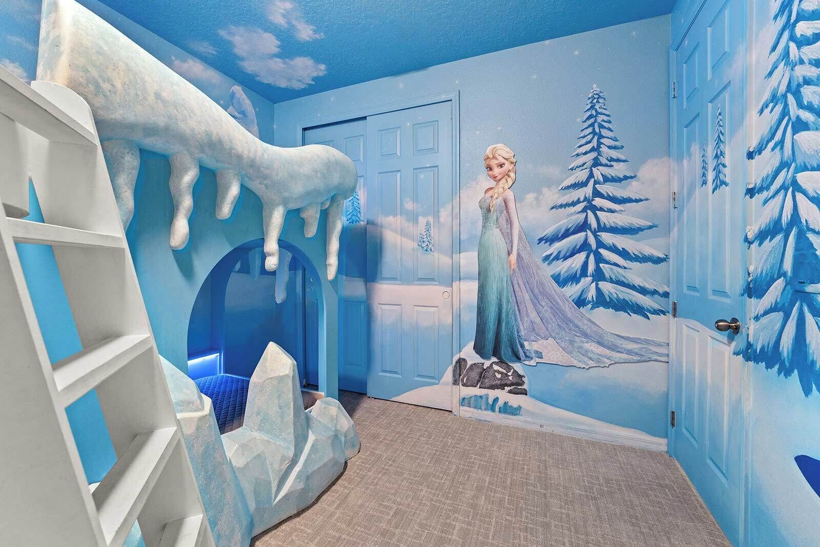Ein Zimmer mit Wandgemälde einer Winterlandschaft, einer Tür und einem weißen Regalschrank.