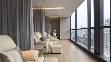 A modern living room with a sofa set, a coffee table, and a view of the city through large windows.