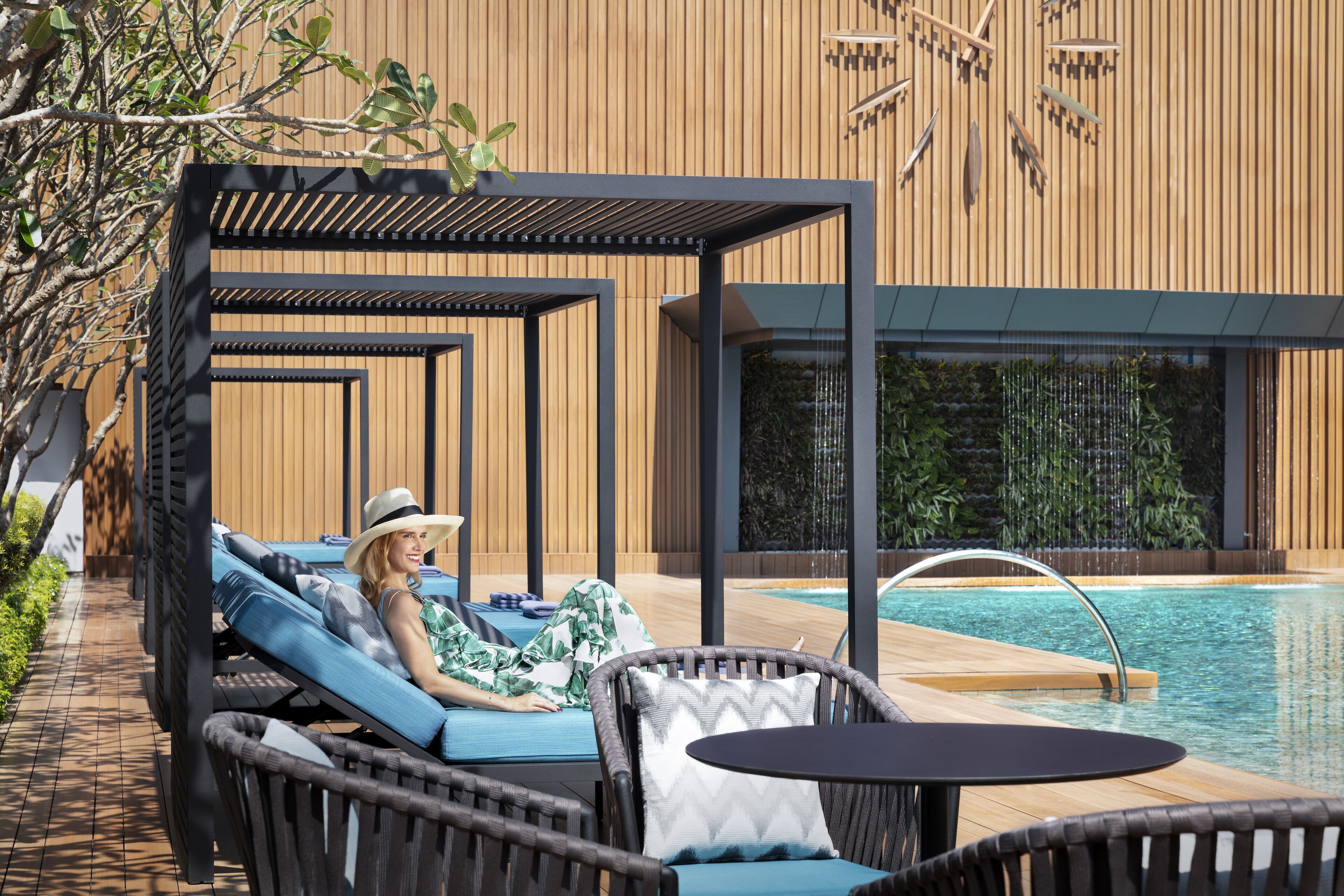 A poolside area with lounge chairs and a pergola.