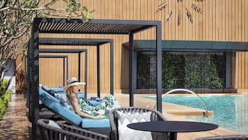 A poolside area with lounge chairs and a pergola.